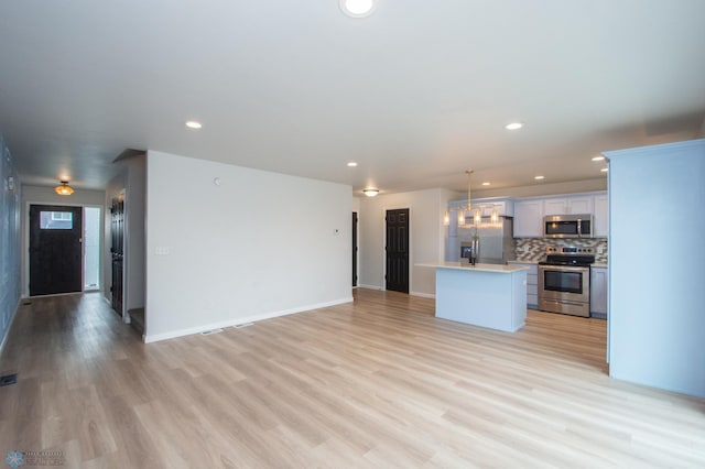 7364 27th St S, Fargo, ND 58104 - unfurnished living room with recessed lighting, light wood-style floors, and baseboards