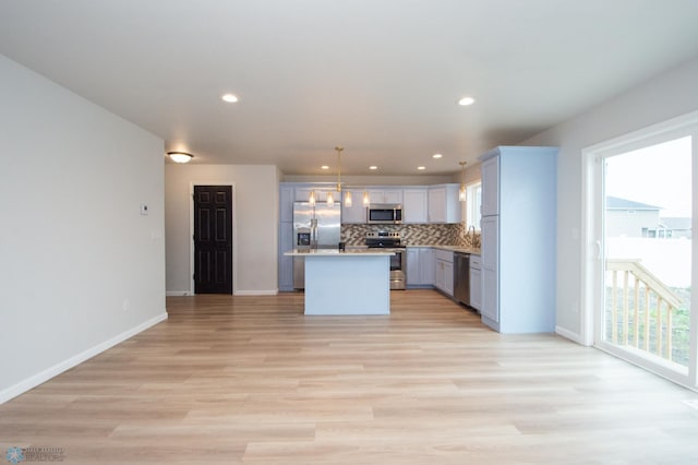 7364 27th St S, Fargo, ND 58104 - kitchen featuring stainless steel appliances, backsplash, open floor plan, light wood-style floors, and recessed lighting