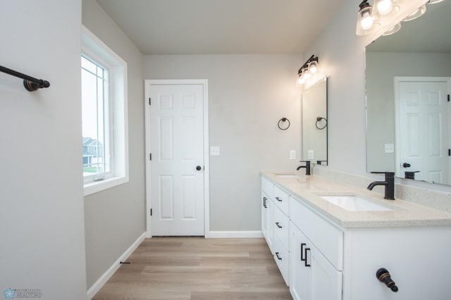 7364 27th St S, Fargo, ND 58104 - bathroom with healthy amount of natural light, double vanity, wood finished floors, and baseboards