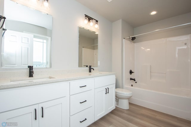 7364 27th St S, Fargo, ND 58104 - bathroom with toilet, double vanity, wood finished floors, shower / bath combination, and recessed lighting