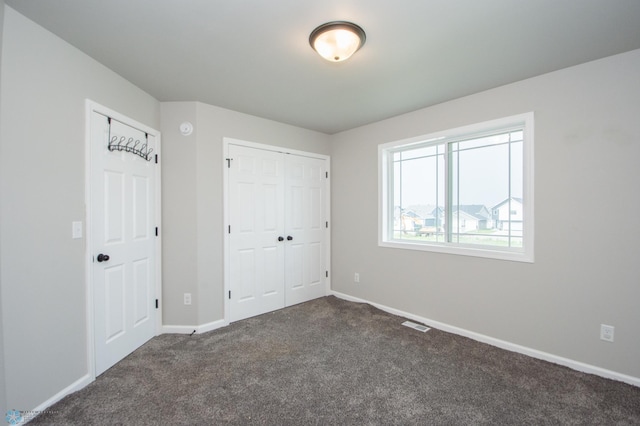 7364 27th St S, Fargo, ND 58104 - unfurnished bedroom featuring dark carpet, baseboards, and a closet
