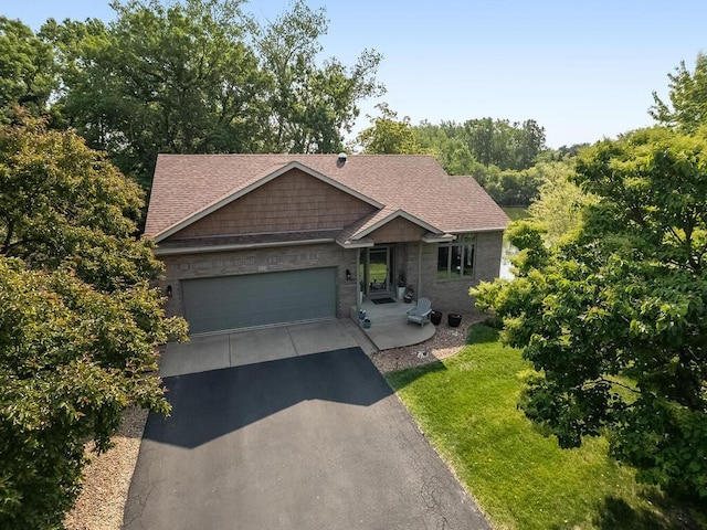 1875 26th Ave NW, New Brighton, MN 55112 - view of front of house featuring driveway, a garage, roof with shingles, and a front lawn
