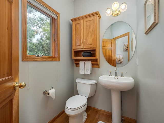 1875 26th Ave NW, New Brighton, MN 55112 - half bathroom with toilet, wood finished floors, baseboards, and a sink
