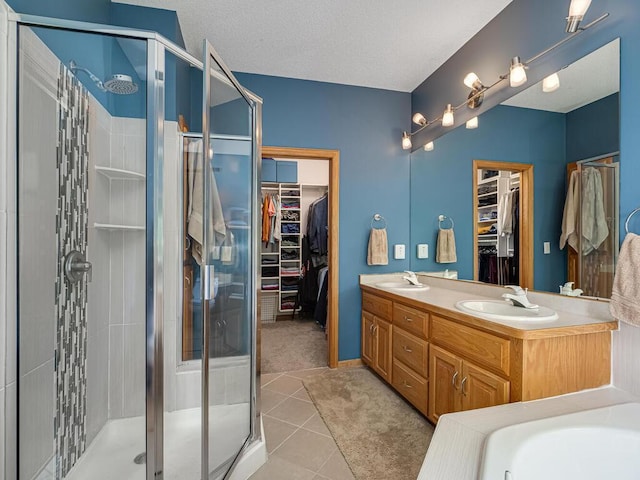 1875 26th Ave NW, New Brighton, MN 55112 - bathroom featuring a walk in closet, a shower stall, double vanity, tile patterned floors, and a textured ceiling