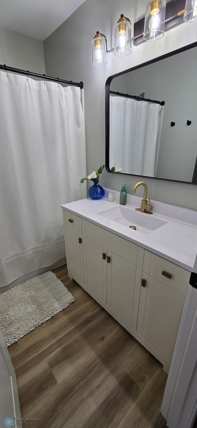 1442 11th Ave S, Fargo, ND 58103 - full bath featuring wood finished floors, vanity, and a shower with curtain
