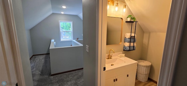 1442 11th Ave S, Fargo, ND 58103 - bathroom featuring vaulted ceiling, vanity, and baseboards