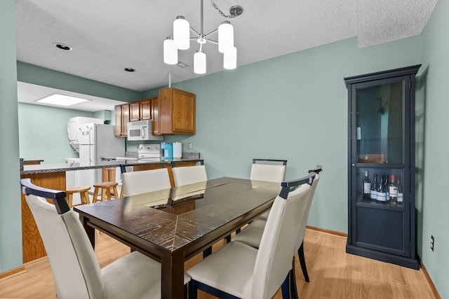 3625 Gettysburg Ave S Unit 40, Saint Louis Park, MN 55426 - dining space with light wood-type flooring, baseboards, a chandelier, and a textured ceiling