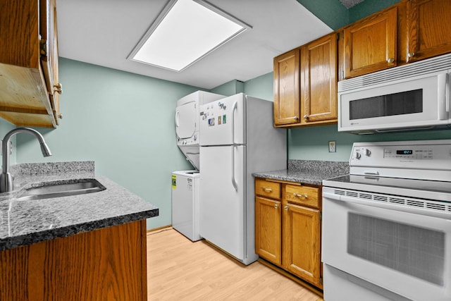 3625 Gettysburg Ave S Unit 40, Saint Louis Park, MN 55426 - kitchen with white appliances, a sink, stacked washing machine and dryer, light wood-type flooring, and brown cabinetry