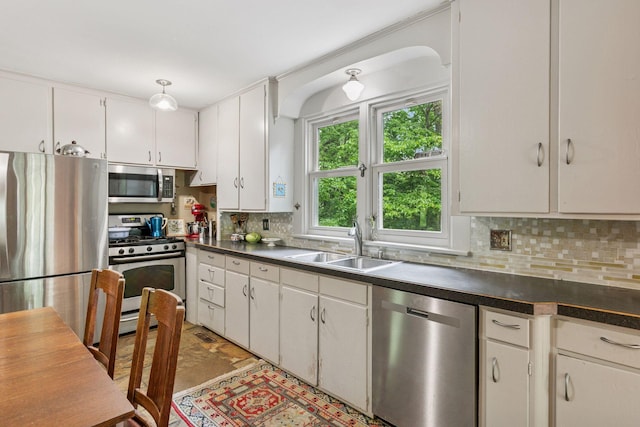 8482 150th St E, Northfield Twp, MN 55057 - kitchen with stainless steel appliances, dark countertops, a sink, tasteful backsplash, and white cabinetry