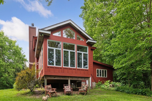 8482 150th St E, Northfield Twp, MN 55057 - rear view of house featuring a chimney, a lawn, and board and batten siding