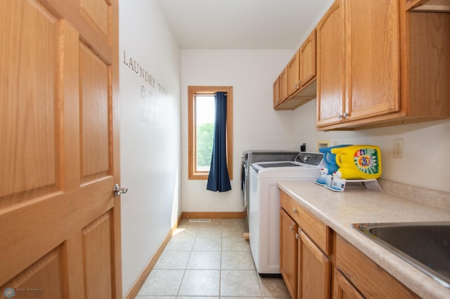 11905 Hunter Dr, Lake Park Twp, MN 56554 - laundry area featuring separate washer and dryer, cabinet space, light tile patterned floors, and baseboards