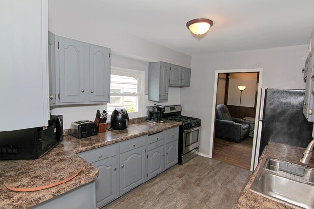 1979 Polaris Pl N, Saint Paul, MN 55109 - kitchen featuring stainless steel appliances, gray cabinetry, light wood-style flooring, and dark countertops