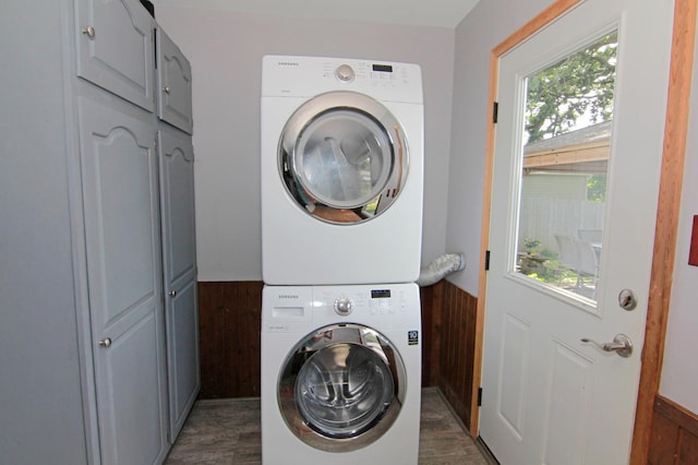 1979 Polaris Pl N, Saint Paul, MN 55109 - laundry room with cabinet space, stacked washer / dryer, wood finished floors, and a wainscoted wall