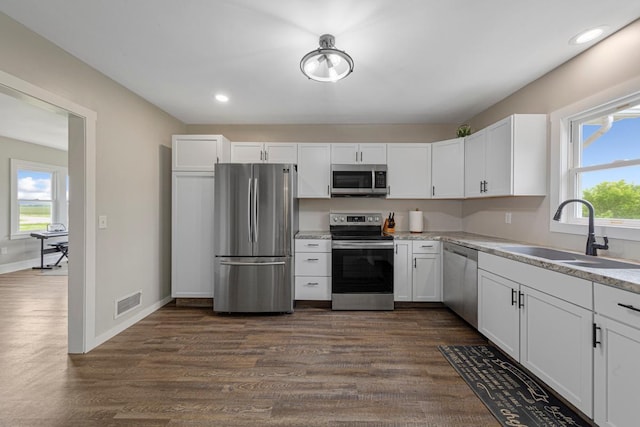 28145 State Highway 112, Le Sueur, MN 56058 - kitchen featuring appliances with stainless steel finishes, a sink, white cabinetry, dark wood-type flooring, and recessed lighting