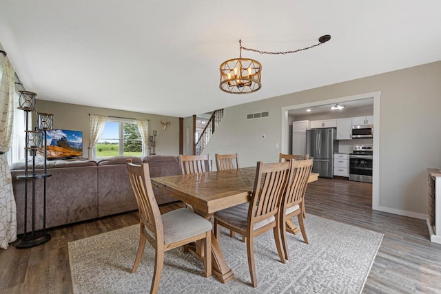 28145 State Highway 112, Le Sueur, MN 56058 - dining area featuring a chandelier, light wood-style floors, stairs, and baseboards
