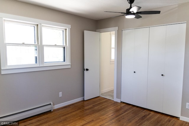1322 17th St W, Hastings, MN 55033 - unfurnished bedroom with a baseboard heating unit, multiple windows, wood finished floors, and a closet