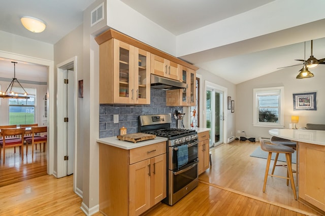 244 Macalester St, Saint Paul, MN 55105 - kitchen featuring range with two ovens, under cabinet range hood, light wood finished floors, decorative backsplash, and lofted ceiling