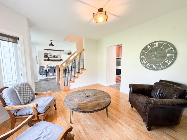 1207 Martin St, Fergus Falls, MN 56537 - living area featuring stairs, light wood-type flooring, and baseboards