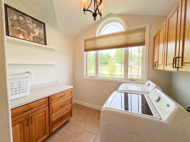 1207 Martin St, Fergus Falls, MN 56537 - laundry room featuring washer and clothes dryer, cabinet space, light tile patterned floors, a chandelier, and baseboards