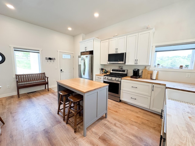 1207 Martin St, Fergus Falls, MN 56537 - kitchen with stainless steel appliances, a kitchen breakfast bar, wood counters, plenty of natural light, and recessed lighting