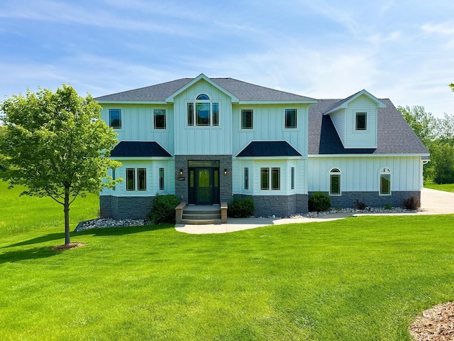 1207 Martin St, Fergus Falls, MN 56537 - view of front facade with stone siding, board and batten siding, a front yard, and roof with shingles