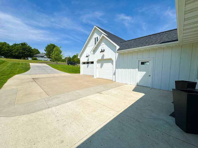 1207 Martin St, Fergus Falls, MN 56537 - view of side of property featuring roof with shingles, driveway, board and batten siding, and a lawn