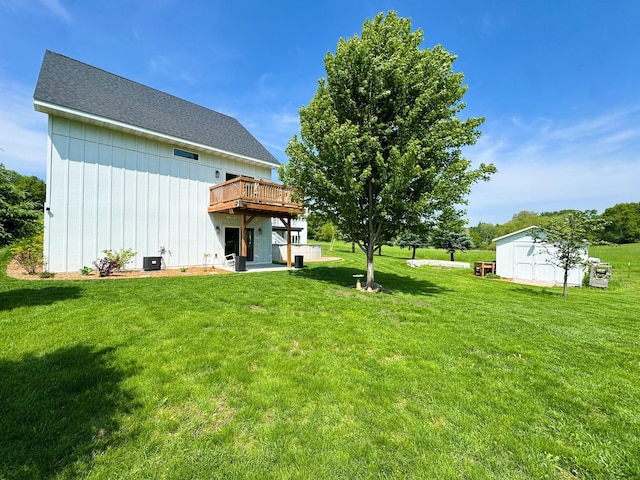 1207 Martin St, Fergus Falls, MN 56537 - rear view of property with board and batten siding, a deck, a lawn, and roof with shingles