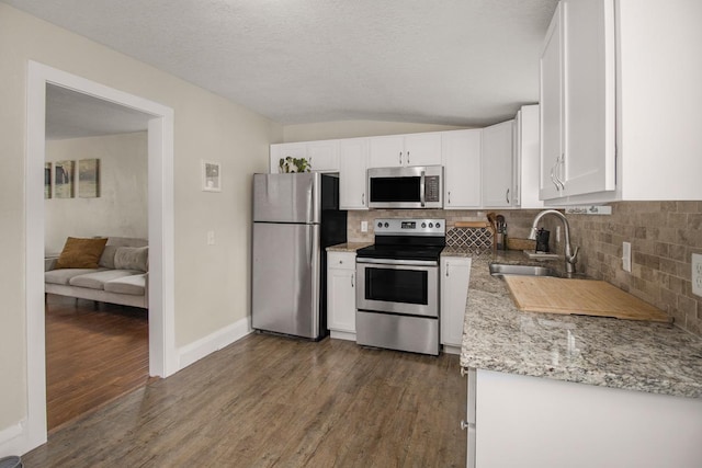 915 Cottage Ave E, Saint Paul, MN 55106 - kitchen with appliances with stainless steel finishes, a sink, white cabinetry, backsplash, and dark wood-style floors