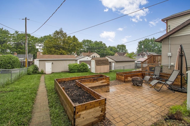 915 Cottage Ave E, Saint Paul, MN 55106 - view of patio with a vegetable garden and an outdoor fire pit