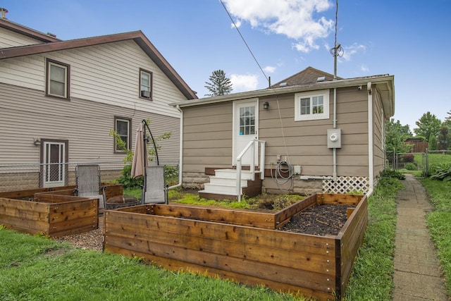 915 Cottage Ave E, Saint Paul, MN 55106 - rear view of property featuring a vegetable garden and entry steps