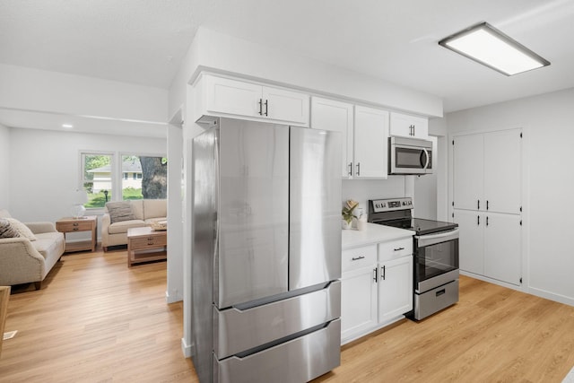 13001 Glenview Dr, Burnsville, MN 55337 - kitchen with stainless steel appliances, open floor plan, light wood-style floors, white cabinetry, and recessed lighting