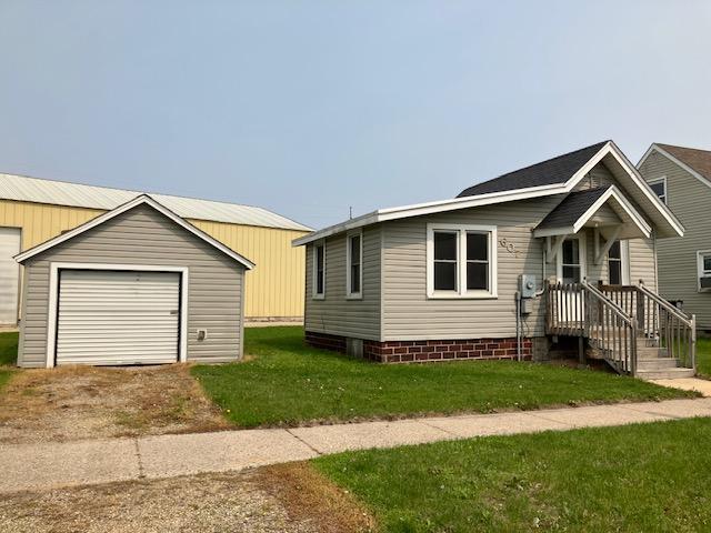607 3rd St SW, Waseca, MN 56093 - view of front facade with an outdoor structure, a front lawn, and driveway