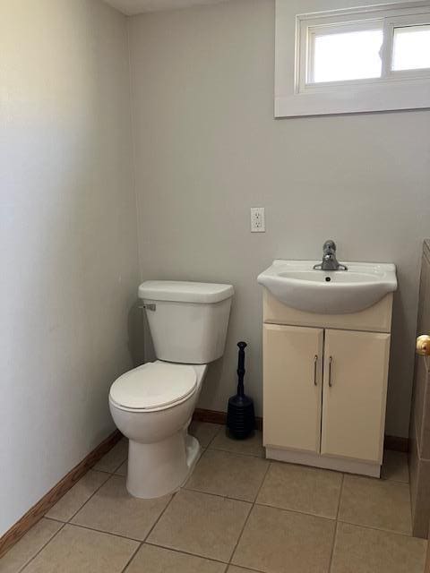607 3rd St SW, Waseca, MN 56093 - half bathroom featuring vanity, toilet, tile patterned floors, and baseboards