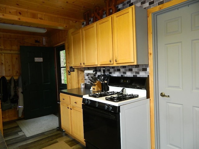 3749 Grizzly Ln, Barnum Twp, MN 55707 - kitchen featuring gas range oven, dark wood-style flooring, decorative backsplash, dark countertops, and wooden ceiling