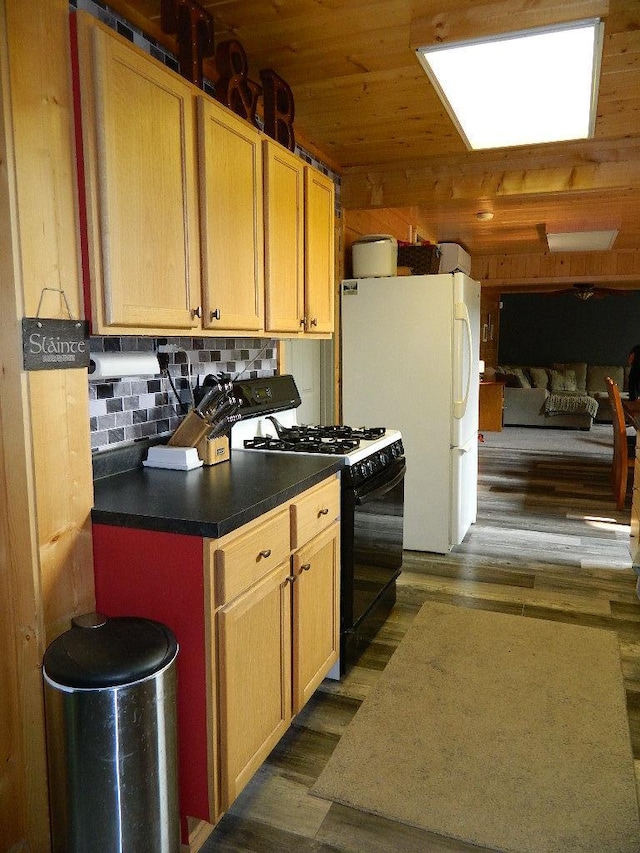 3749 Grizzly Ln, Barnum Twp, MN 55707 - kitchen featuring black gas stove, freestanding refrigerator, dark wood finished floors, decorative backsplash, and dark countertops