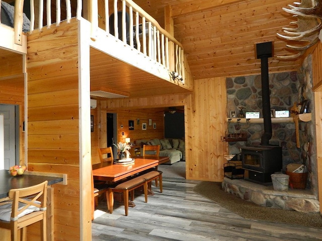 3749 Grizzly Ln, Barnum Twp, MN 55707 - living room with wood walls, a wood stove, wood finished floors, and high vaulted ceiling