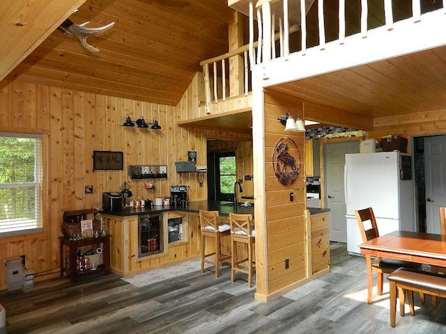 3749 Grizzly Ln, Barnum Twp, MN 55707 - kitchen with freestanding refrigerator, lofted ceiling, wood walls, dark countertops, and wood finished floors
