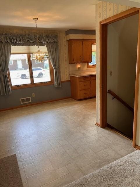 5951 Oakwood Mnr NE, Fridley, MN 55432 - unfurnished dining area with a chandelier, healthy amount of natural light, and baseboards