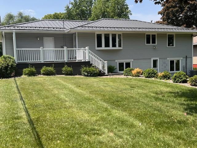 5951 Oakwood Mnr NE, Fridley, MN 55432 - view of front of house featuring a standing seam roof, a front lawn, and metal roof