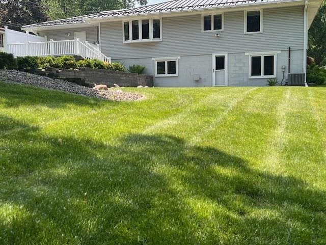 5951 Oakwood Mnr NE, Fridley, MN 55432 - rear view of property featuring a standing seam roof, metal roof, a yard, and central AC unit