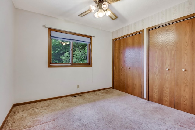 544 22nd St, Sioux Creek Twp, WI 54728 - unfurnished bedroom featuring multiple closets, carpet flooring, baseboards, and a ceiling fan