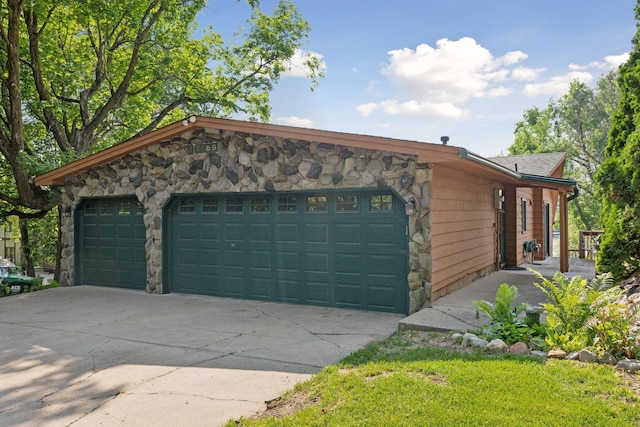 7469 Fernbrook Ln N, Maple Grove, MN 55311 - view of front of home with stone siding, concrete driveway, and a garage