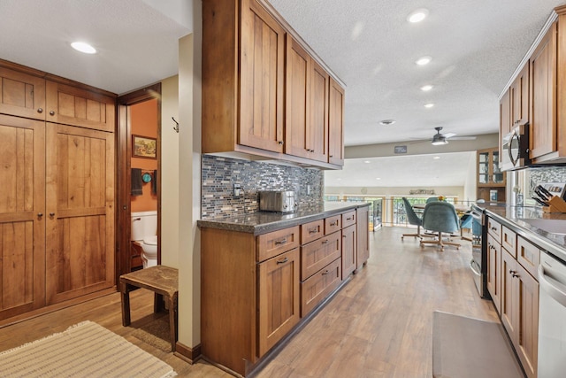 7469 Fernbrook Ln N, Maple Grove, MN 55311 - kitchen featuring stainless steel microwave, brown cabinets, light wood-style floors, a ceiling fan, and recessed lighting