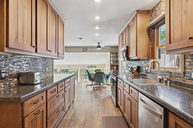 7469 Fernbrook Ln N, Maple Grove, MN 55311 - kitchen featuring appliances with stainless steel finishes, a sink, a textured ceiling, a ceiling fan, and brown cabinetry