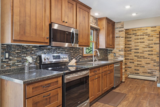 7469 Fernbrook Ln N, Maple Grove, MN 55311 - kitchen featuring appliances with stainless steel finishes, a sink, baseboard heating, tasteful backsplash, and a textured ceiling