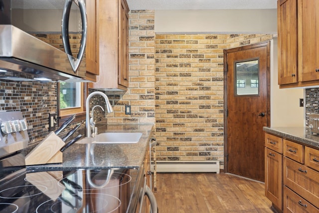 7469 Fernbrook Ln N, Maple Grove, MN 55311 - kitchen with stainless steel microwave, a sink, brown cabinetry, tasteful backsplash, and baseboard heating
