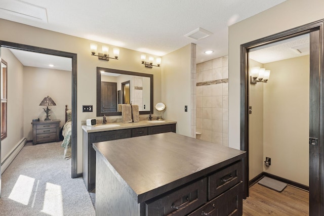 7469 Fernbrook Ln N, Maple Grove, MN 55311 - kitchen with a sink, baseboard heating, baseboards, and a textured ceiling