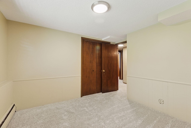 7469 Fernbrook Ln N, Maple Grove, MN 55311 - unfurnished bedroom featuring a baseboard radiator, carpet, a closet, and a wainscoted wall