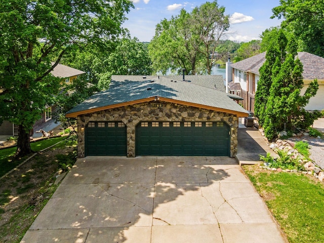 7469 Fernbrook Ln N, Maple Grove, MN 55311 - view of front facade featuring stone siding, driveway, an attached garage, and roof with shingles