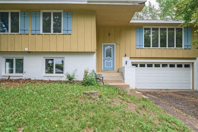 1813 Stinson Blvd, New Brighton, MN 55112 - view of front of house with dirt driveway, entry steps, a garage, and brick siding